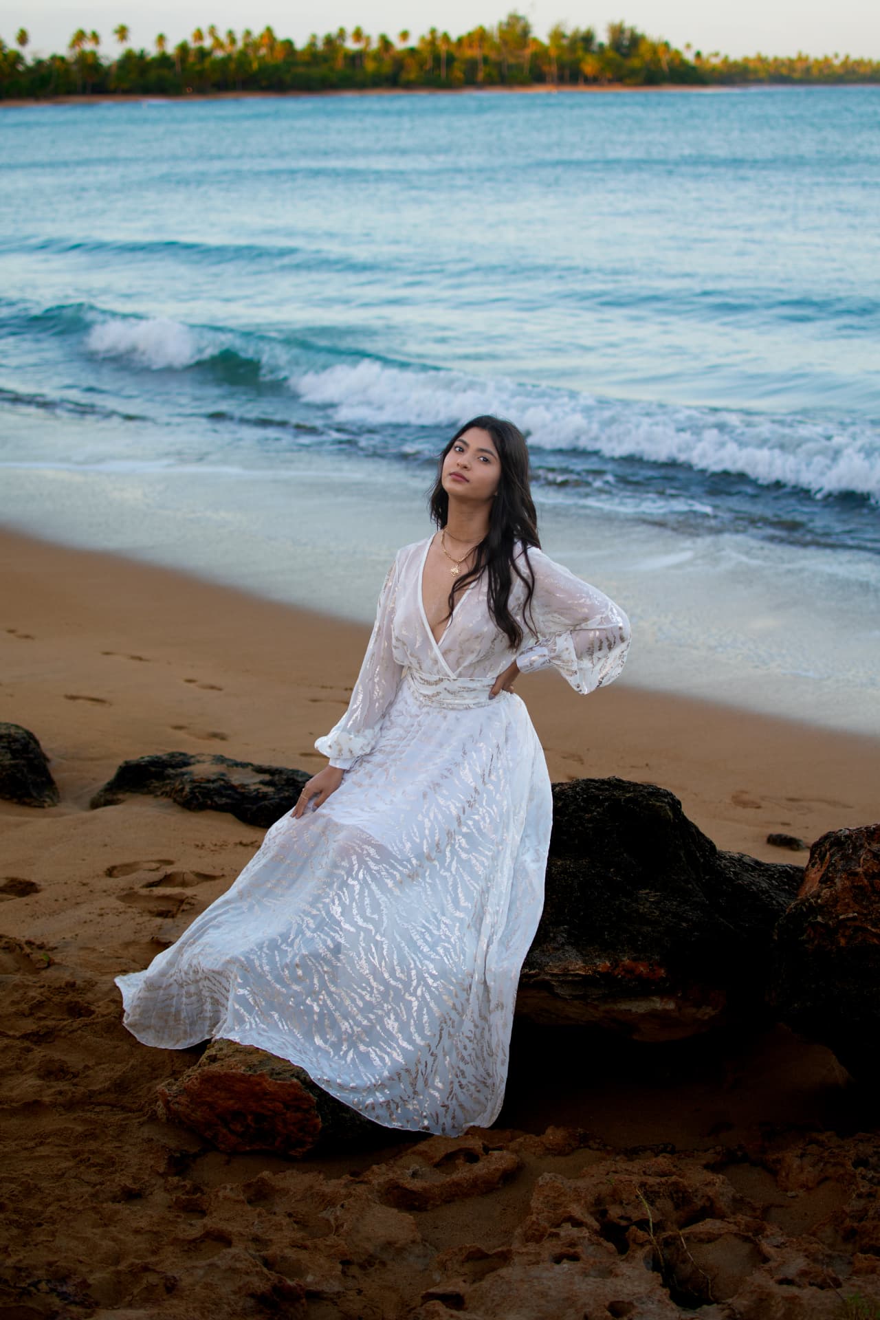 Retrato en la playa al atardecer con vestido blanco