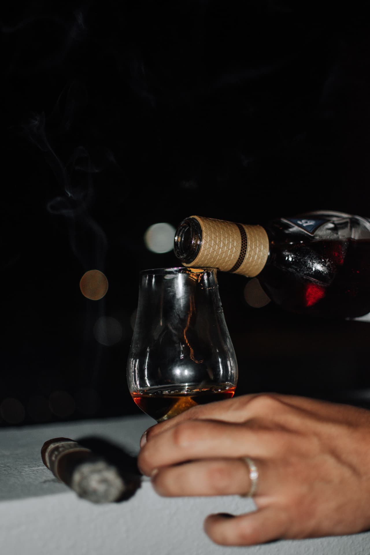 Sirviendo whisky junto a un cigarro